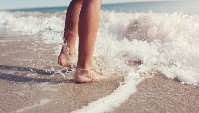Feet in the sea on the beach