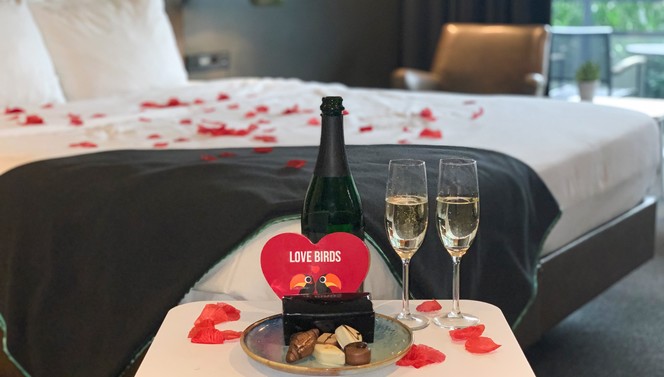Romantic | Hotel room | Rose petals | Bottle of bubbles